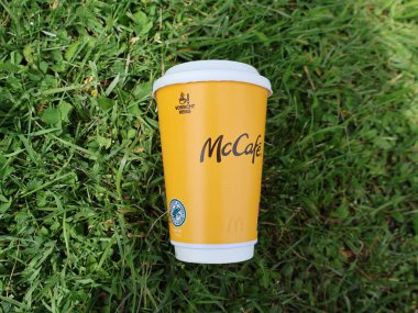29.05.2025 Almanya: Atılmış bir McDonalds McCafe kahve fincanı halka açık bir alanda yeşil çimlerin üzerinde yatmaktadır. Görüntü, tek kullanımlık fast food kaynaklı çevre kirliliği sorununu vurguluyor