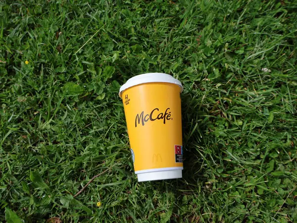 29.05.2025 Almanya: Halka açık bir alanda yeşil çimlerin üzerinde duran tek kullanımlık bir McCafe kahve fincanı. Görüntü çevresel kirliliği ve fast food ambalaj atıklarını temsil ediyor.