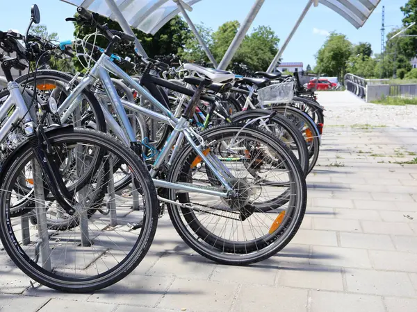 31.05.2025 Almanya: Bisiklet Sırası Bir Açık-Hava Bisiklet Standında Park Edildi. Güneşli bir günde kaldırım ve yeşilliklerle çevrili bisikletler düzgünce bir bisiklet standına park edilir. Sahne