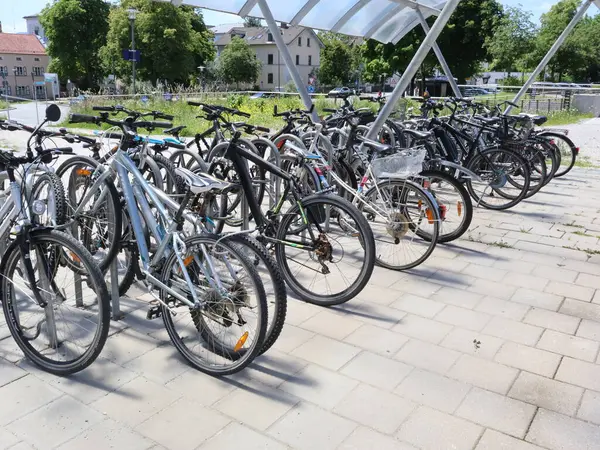 31.05.2025 Almanya: Kentsel bir alanda bir gölgelik altında park etmiş çok sayıda bisiklet, çevre dostu ulaşım ve kentsel bisiklet kültürünü ön plana çıkarıyor. Fotoğraf yeşil arkaplanlı güneşli bir zemine göre ayarlanmış.