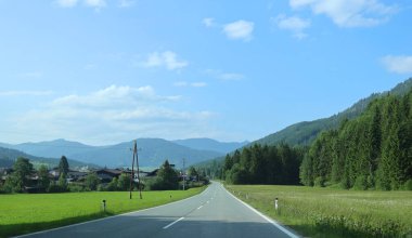 Austrian Yolu, Orman Manzaralı Alp Dağı Köyü 'ne çıkıyor. Sakin bir yol yeşil tepelerin arasına yerleşmiş sakin ormanlarla çevrili tuhaf bir köye doğru uzanıyor.