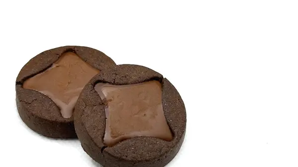 Yuvarlak çikolatalı bisküviler, beyaz arka planda izole edilmiş yıldız şeklinde çikolata kreması.