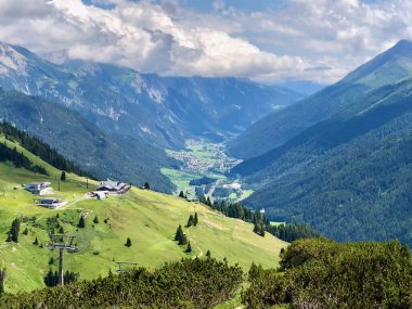 Avusturya Alpleri 'ndeki vadiye bir tepeden bak. Gampen 'in yanı sıra St. Anton am Arlberg' de orman ve yeşil çayırları görebilirsiniz..