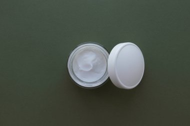 Fotokopi alanı olan yeşil arkaplanda beyaz kozmetik kavanoz