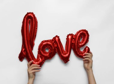 Kırmızı kalp, gri arkaplandaki aşkla şekillendirilmiş kelime.