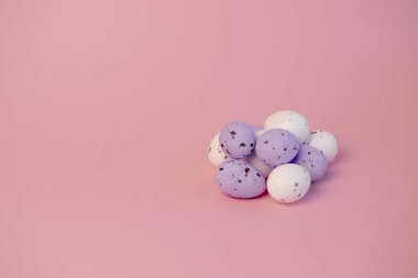 Pembe arka planda mor çiçekli yumurtalar. Paskalya konsepti.
