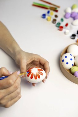 Dişi bir el fırçayla yumurta boyuyor..