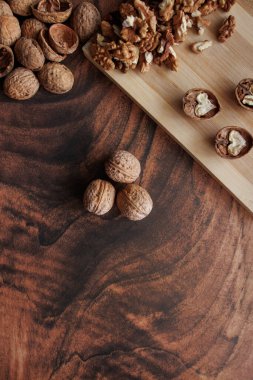 Tahtanın yanında, karanlık bir arka planda cevizler.