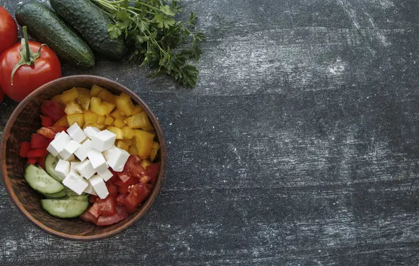 Siyah ahşap arka planda salata pişirmek için malzemeler..