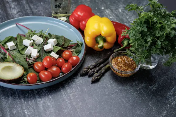 Arka planda taze sebze salatası. Vejetaryen yiyecekler. Taze sebzeler, yeşiller, dolmalık biberli peynir, kuşkonmaz, hardal tohumu, sağlıklı beslenme.