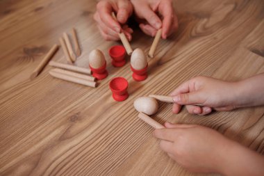 Tahtada tahta sopalarla oynayan çocuk elleri..