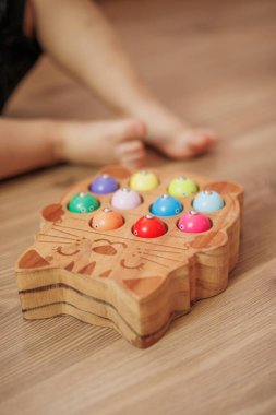 Ahşap bir masanın yakın plan fotoğrafı. Elinde oyuncak tutan bir el.