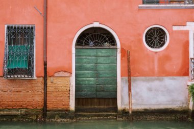 The stunningly beautiful canals in Venice highlight the vibrant array of colorful boats alongside historic buildings clipart