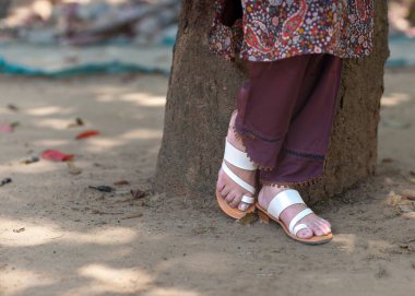 A woman wearing floral design Indian chappals clipart