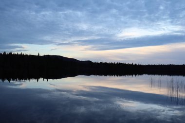 Suyun yansımasıyla sonbaharda güzel bir manzara. Akşamları huzurlu ve sakin bir ortam, göl ve güzel bir gökyüzü. Doğa ve parkın çevresi ve korunumu.