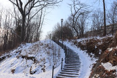 Kışın dışarıdaki merdivenler ve parkta şehir planlaması. Açık hava mimarisi ve Aralık manzarası. Kış takvimi ve patika yolu ile park geliştirme.