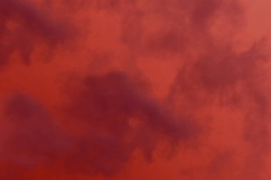 Koyu bulutlu kırmızı ve turuncu bir arka plan. Kırmızı arka planda sis veya duman çizimi. Ateş dumanı ve kızıl gökyüzü.