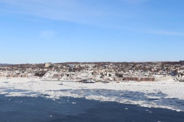 Bir manzara ve kışın nehir manzarası ve Quebec manzarası. Uçsuz bucaksız bir nehir, bir ufuk ve mavi gökyüzü olan kış takvimi. St Laurent nehri ve Levis kıyı şeridi..