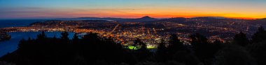Günbatımı gökyüzü ve Dunedin 'in gece manzarası Yeni Zelanda, Dunedin' deki Sinyal Tepesi Gözcüleri 'nden görüldüğü gibi.