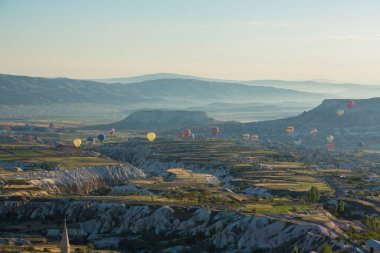 Kapadokya 'daki Uchisar Şatosu' ndan Goreme Milli Parkı üzerinde uçan sıcak hava balonu görülüyor