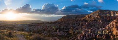 Kapadokya 'daki Goreme Milli Parkı' nda tuhaf kayalar, mağara evleri ve günbatımı gökyüzü