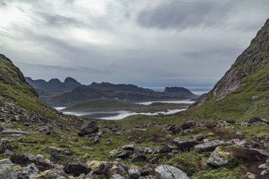 Bereketli çayırların, Lofoten Adaları 'ndaki sisli bir gökyüzünün altında dramatik dağ sırtları ve dingin tarlalarla buluştuğu Fredvang üzerinde nefes kesici bir manzara beliriyor..