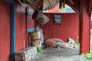 Lofoten Adaları, Nordland 'da canlı bir kırmızı balıkçı evi, bölgenin deniz tarihi ve cazibesini yansıtan balıkçı ağları ve ahşap fıçıları içeren rustik bir dekor içeriyor..