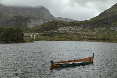 Norveç 'in güzel Lofoten Adaları' ndaki yemyeşil ve yüksek dağların çerçevelediği huzurlu bir gölde tek başına sürüklenen bir kano huzur hissi uyandırıyor..