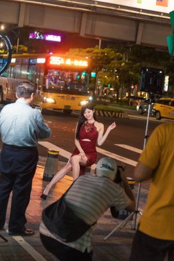 Taipei, Tayvan - 10 Ekim 2019: Çarpıcı bir model canlı bir gece çekimi sırasında Taipei 'nin hareketli sokaklarında zarifçe poz veriyor