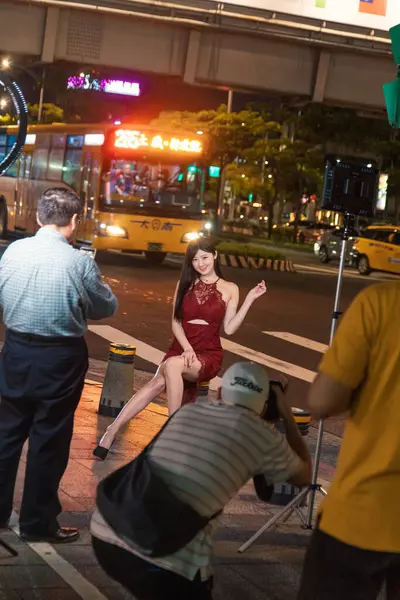 Taipei, Tayvan - 10 Ekim 2019: Çarpıcı bir model canlı bir gece çekimi sırasında Taipei 'nin hareketli sokaklarında zarifçe poz veriyor