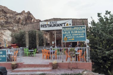 Fas 'ın dağlarının arasına yerleşmiş bu kafe restoranında renkli oturma yerleri ve tabelalar var. Huzurlu bir manzarada rahatlama ve yerel tatlar arayan ziyaretçileri cezbediyor.