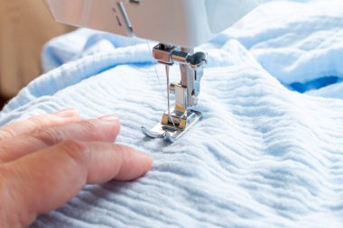 Ev ortamında dikiş makinesine, dikiş iğnesine ve ellere yakın çekim. Yüksek kalite fotoğraf