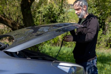 Açık araba kaputunun önünde duran sakallı adam. Araba arızası. Yüksek kalite fotoğraf