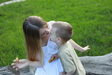 Anne ve oğlu beyaz elbiseli.