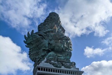 A low-angle view of the upper portion of the Garuda Wisnu Kencana statue in Bali, Indonesia. clipart