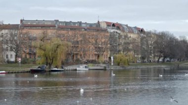 BERLİN, Almanya - 14 ARALIK 2020: Kreuzberg, Berlin 'de Fraenkelufer ve Landwehrkanal. Kanalda kuğular ve tekneler var. Kış günü. 6K 'da vuruldu.