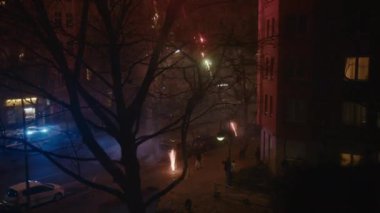 Berlin, Almanya - 31 Aralık 2022: İnsanlar Kreuzberg, Berlin 'de bir sokakta 2023 yılını kutlamak için havaya renkli havai fişekler atıyorlar