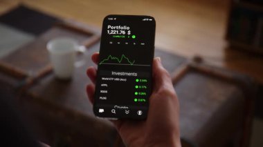 Evde, oturma odasında, Ticaret Uygulaması Model Model 'iyle el ele tutuşup Borsa ve Yatırımların Dolar' da yükselişini izliyoruz. Gençlerin hisse senetlerine yatırım yapma eğilimi. Kamera bir Dolly üzerinde hareket ediyor