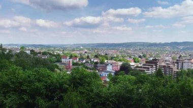 Yüksek Angle Pan, Wuppertal Oberbarmen 'e karşı, parktaki parktaki barmen, güneş ışığı, mavi gökyüzü ve güzel bulutlarla.