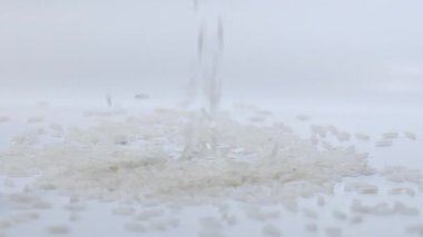 Pirinç yavaş çekimde beyaz bir yüzeye düşüyor. Beyazda izole edilmiş. 120 FPS. 