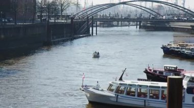 HAMBURG, Almanya - 27 Mart 2022 Hamburg 'daki BINNENHAFEN, İç Liman veya Nehir Limanı' na küçük bir sürat teknesi taşınır. Arka planda Niederbaşemsiyeyi geçen turistler. Güneşli bahar günü.