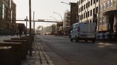 HAMBURG, ALMANY - 27 Mart 2022: Altona 'daki tarihi Holzhafen' de Grosse Elbstrasse caddesinde trafik. Arabalar geçiyor. Öğleden sonra güneşi. Sesle..