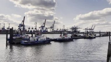 HAMBURG, ALMANY - 19 Mart 2022: Ateş Savaşları Gemisi Fairplay XV ve Hamburg limanındaki diğer römorkörler. Arkaplanda Vinçler. 