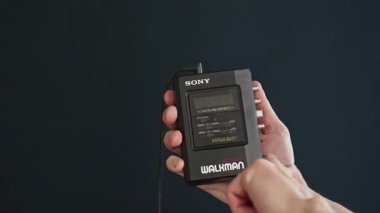 Berlin, Almanya - Nisan 2025: Walkman 'e bir ses kaseti yerleştirmek ve oynatmaya basmak. Sony Walkman WM-B47, 80 'lerde ve 90' larda popüler bir taşınabilir kasetçaydı..