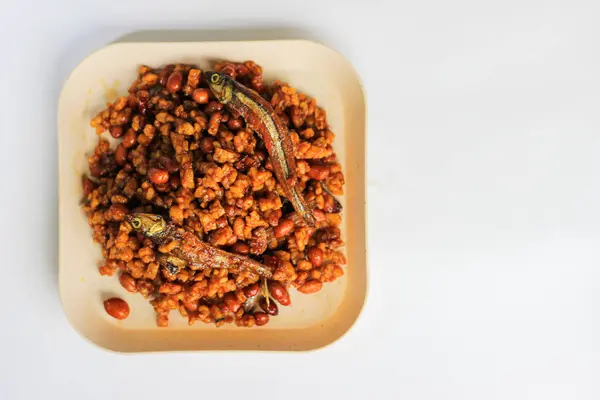 Endonezya yemeği kurutulmuş tempeh, Tempeh ya da soya fasulyesinden yapılır küçük parçalara ayrılır, acı biber, soya sosu ve ançüezle pişirilir, beyaz arka planda izole edilir.