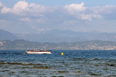 Sirmione, Italy - Sep 21st, 2024: A tour boat carrying tourists cruises across the calm waters of Lake Garda clipart