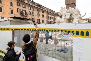 Roma, İtalya - 14 Kasım 2024: Ziyaretçiler, Fontana dei Quattro Fiumi 'nin 2025 yılının yıldönümü boyunca Navona Meydanı' ndaki bariyerleri aşarak fotoğraflarını çekiyorlar