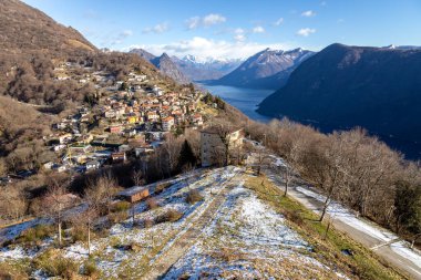 View from Monte Bre of the village, Lake Lugano, the surrounding mountains, and scattered snow, Switzerland clipart