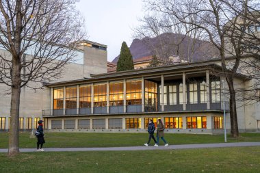 Lugano, İsviçre - 23 Aralık 2024: Parco Ciani Parkı 'nda yürüyen insanlar, Kanton Kütüphanesi Lugano' nun arkasında