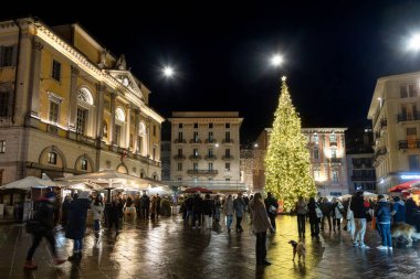 Lugano, İsviçre - 23 Aralık 2024: Piazza della Riforma 'da Noel ağacı, şenlikli süslemeler, insanlar ve gece ışıkları